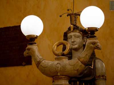Saliamo quindi quattro gradini costeggiati da due sfingi con pavoni speculari usati come lucernari: si tratta delle figlie egizie di Mnemosine, personificazione mitologica della Memoria 